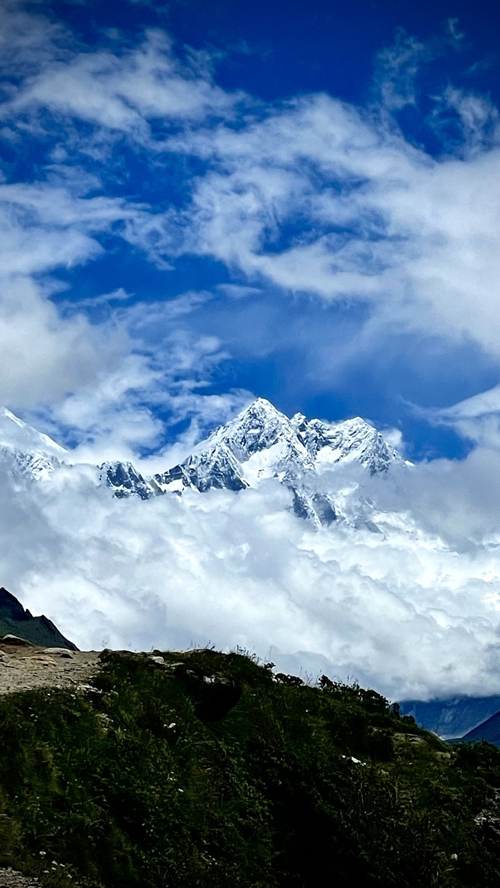 Sommets de montagnes enneigés avec ciel bleu et nuages.