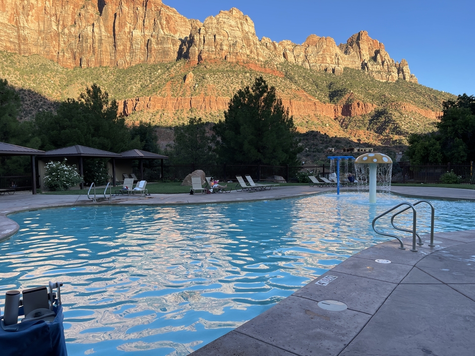 Une piscine avec un décor montagneux en fin d'après-midi.