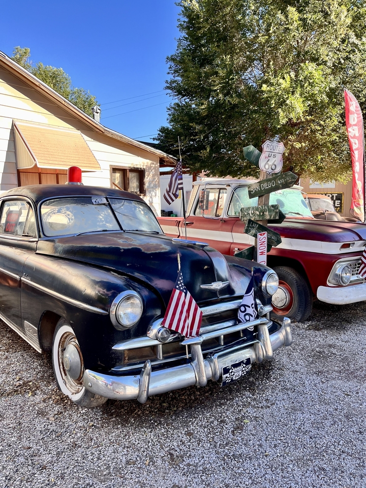 Véhicules vintage et enseignes dans une attraction routière nostalgique.
