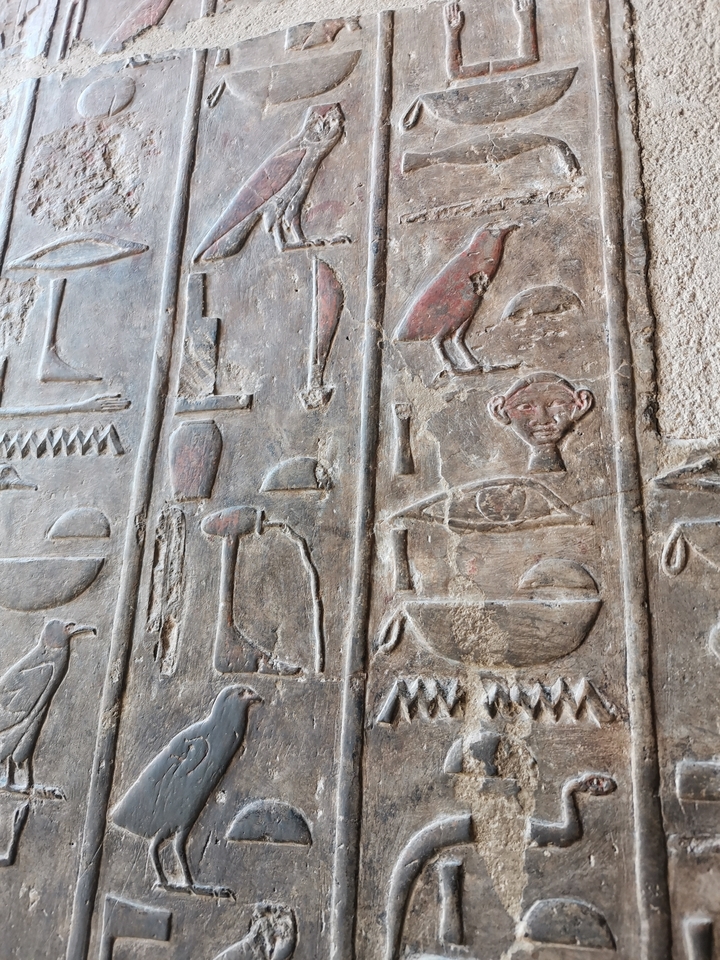 Sculptures égyptiennes antiques sur un mur de pierre.