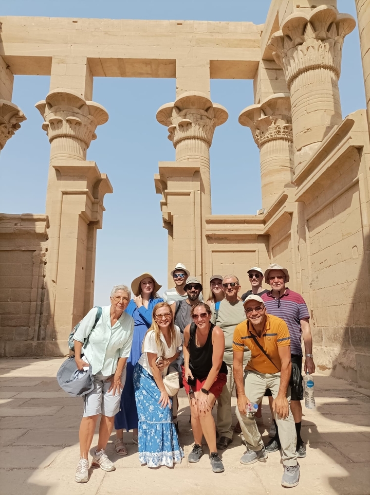 Groupe de touristes devant des ruines égyptiennes antiques.