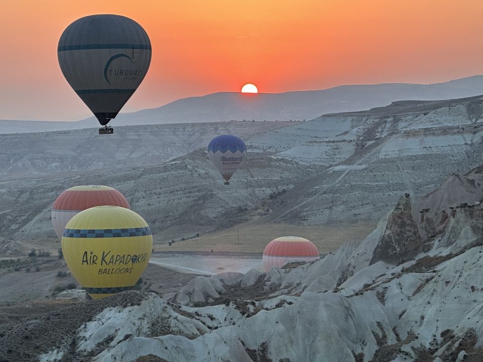 Montgolfières flottant au-dessus d'un paysage rocheux au lever du soleil