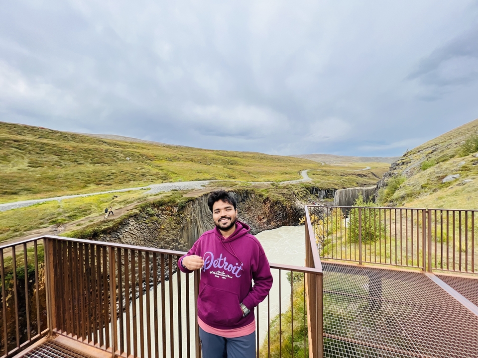 Homme profitant de la vue d'une cascade.