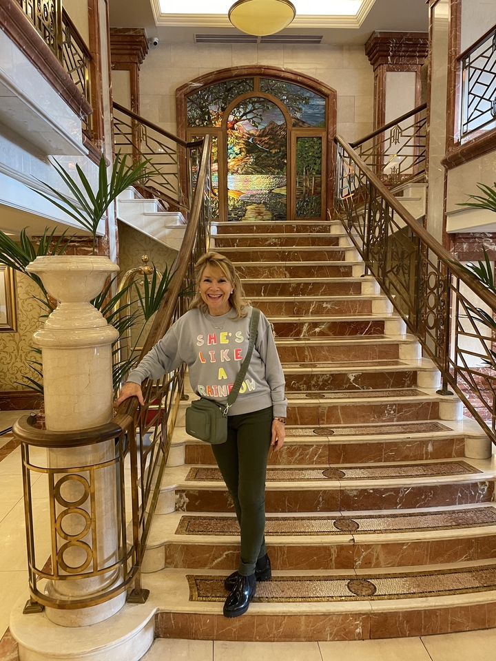 Femme posant sur un escalier à l'intérieur.