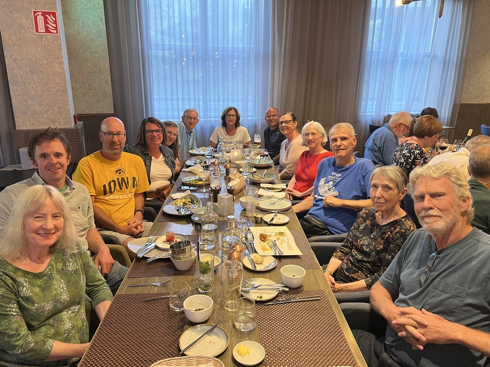 Un grand groupe de personnes réunies autour d'une table à manger.