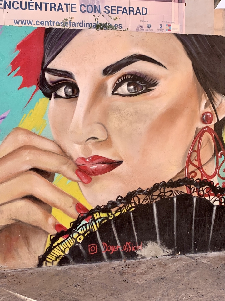 Une fresque détaillée représentant une femme utilisant un éventail.