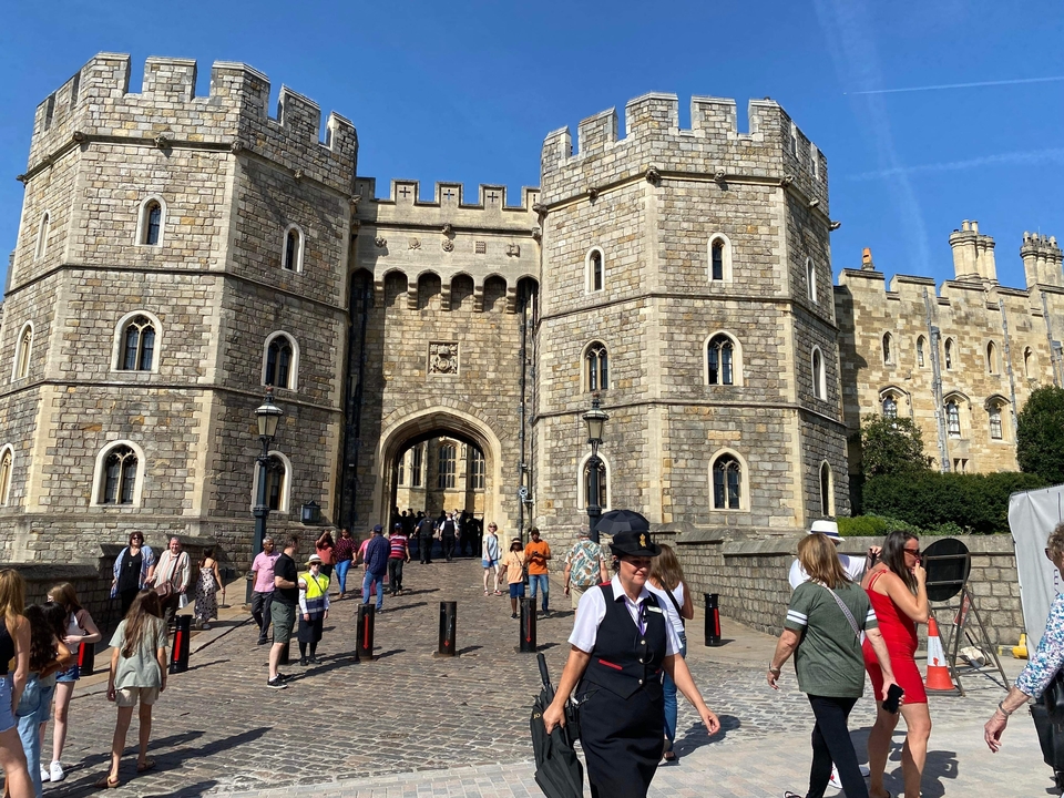Visiteurs entrant par une grande entrée de château.