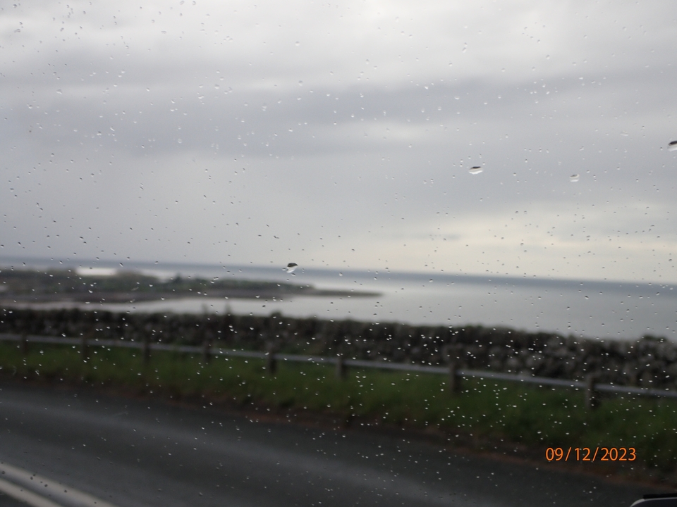 Vue d'une zone côtière à travers une fenêtre pluvieuse.