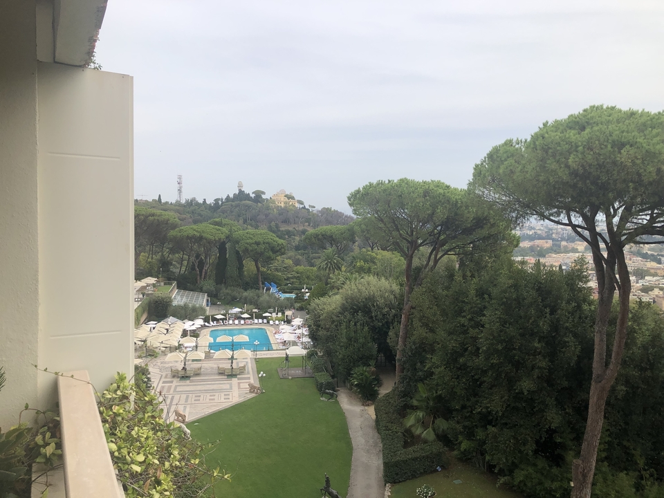 Vue panoramique d'un complexe hôtelier avec une piscine et un paysage luxuriant.
