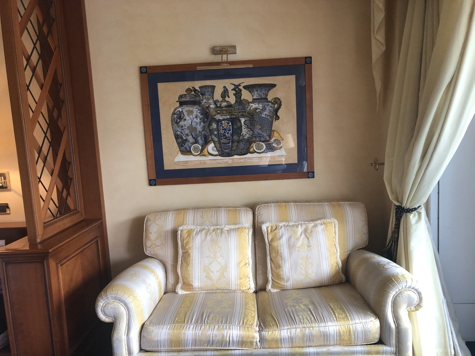 Intérieur d'un salon avec un canapé et un tableau encadré au mur.