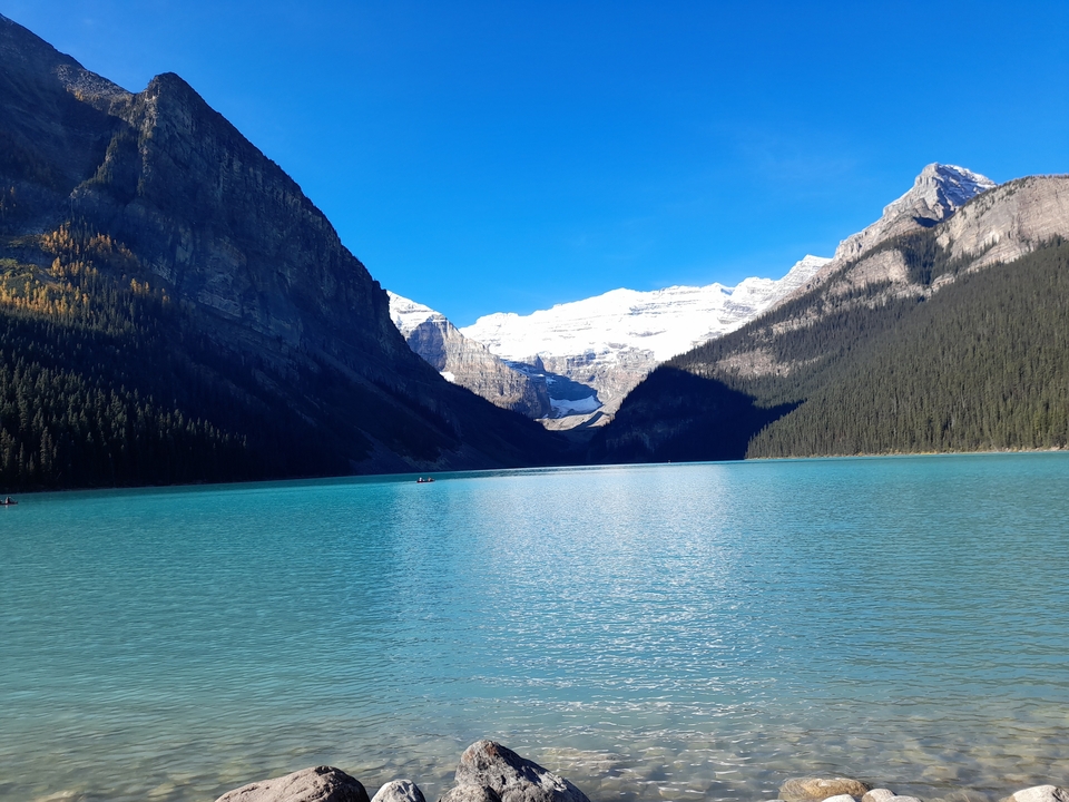 Lac magnifique aux eaux turquoise entouré de montagnes.