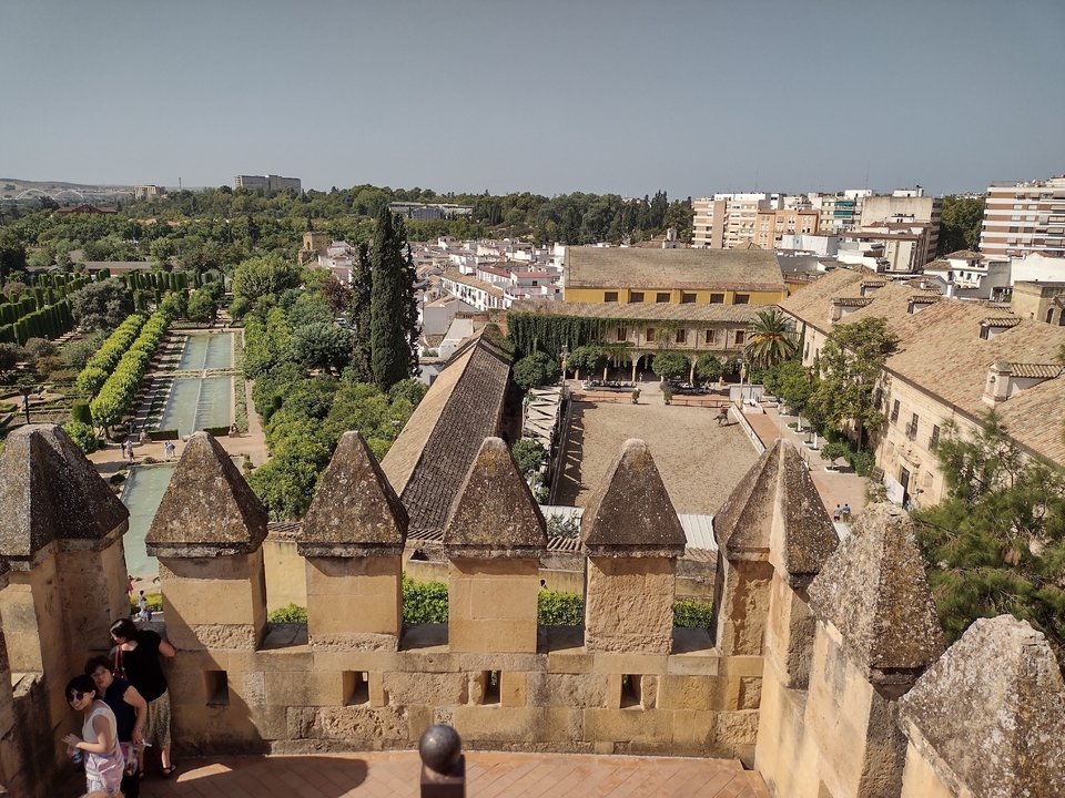 Vue panoramique d'une ville avec architecture historique et jardins.