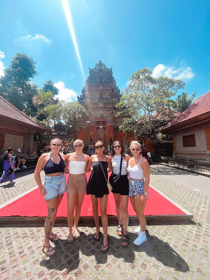 Groupe de touristes devant une architecture de temple traditionnelle.
