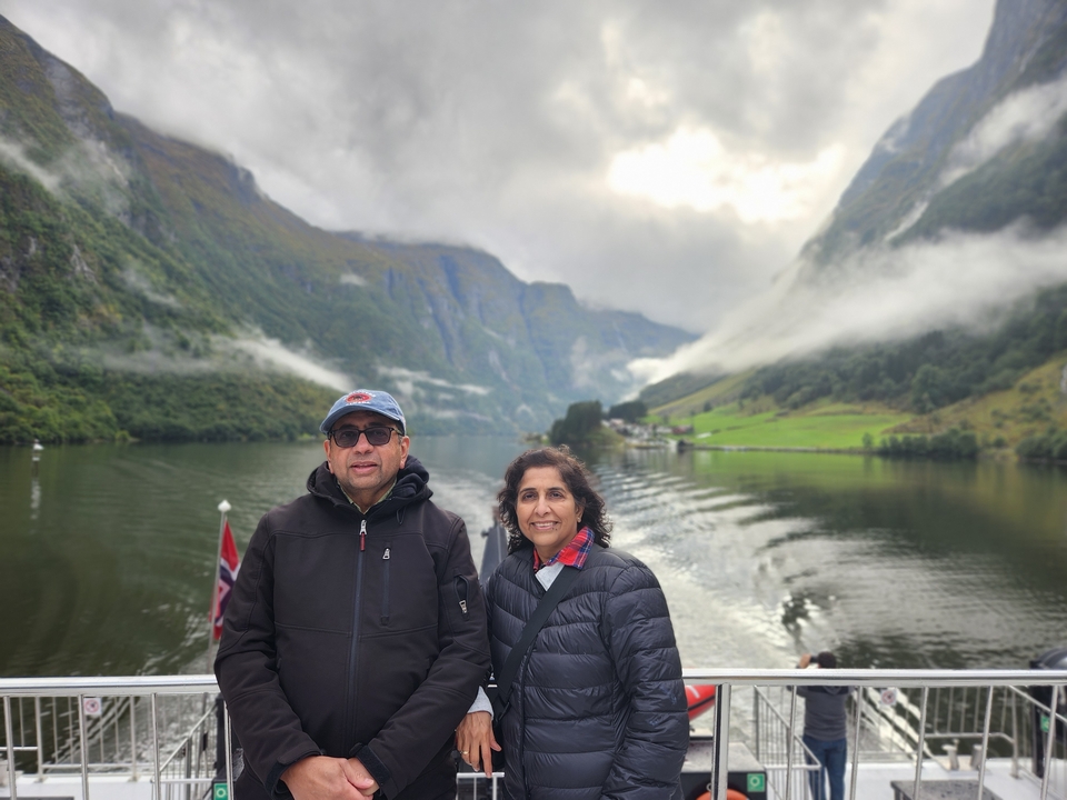 Un couple posant devant un paysage montagneux.