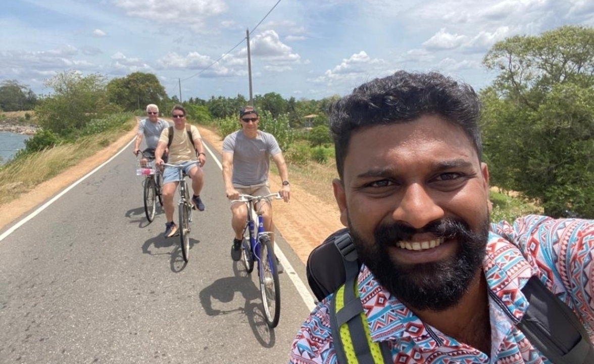 Groupe de cyclistes sur une route avec une personne qui prend un selfie.