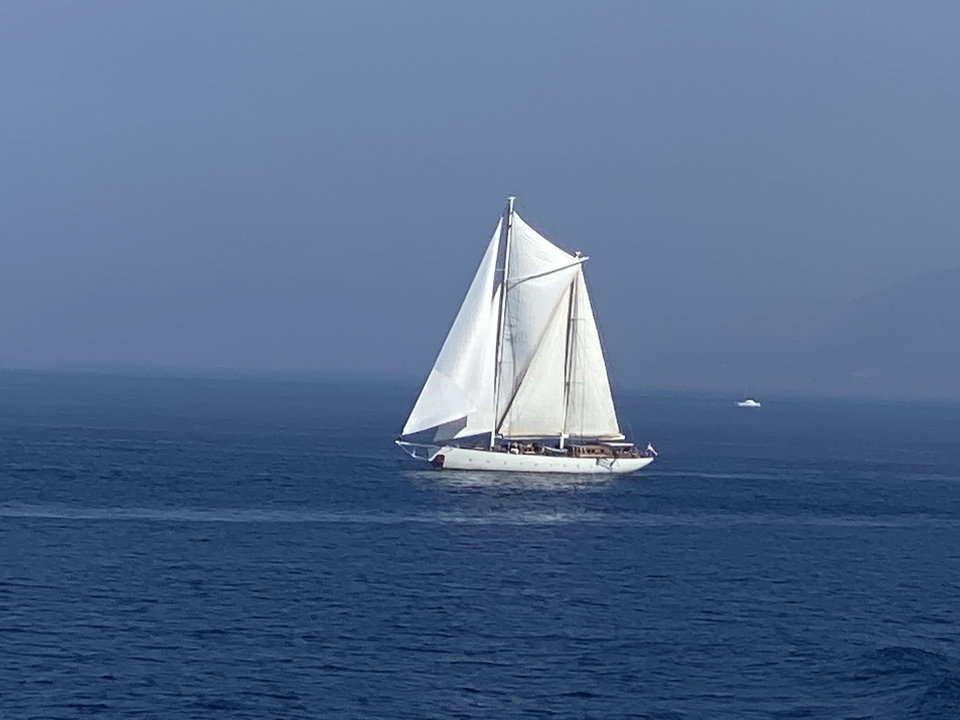 Un voilier avec des voiles blanches sur un océan bleu.