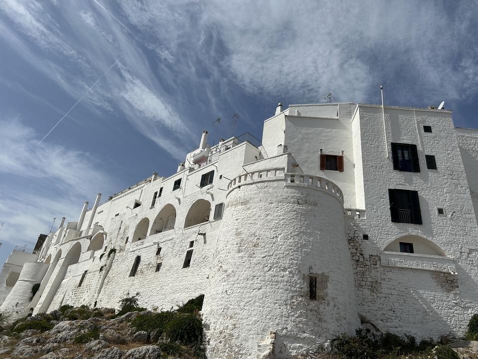 Bâtiments blancs avec des arches et un ciel dégagé.