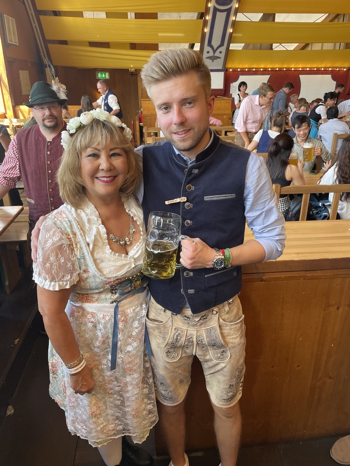 Deux personnes en tenues traditionnelles bavaroises tenant des chopes de bière.