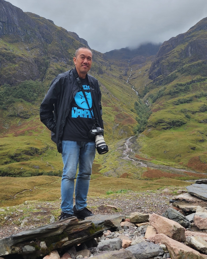 Personne debout dans une zone vallonnée avec un appareil photo.