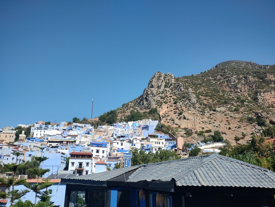 Ville à flanc de colline aux bâtiments bleus.