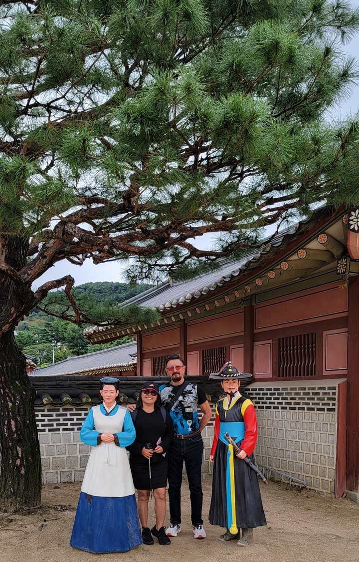Un couple posant devant une architecture coréenne traditionnelle.