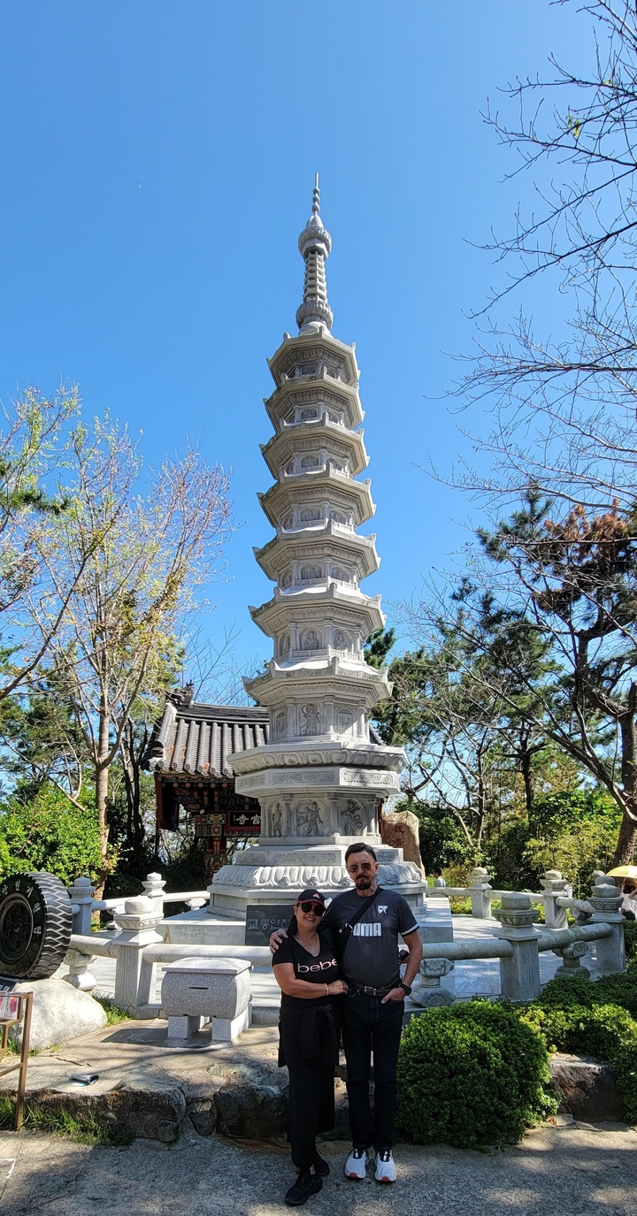 Une pagode haute et richement décorée avec des arbres autour.
