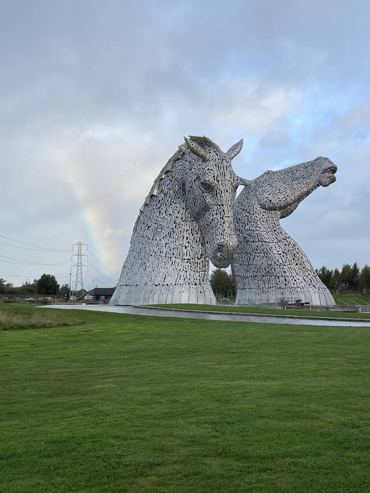 Sculptures géantes de chevaux sur un champ vert.