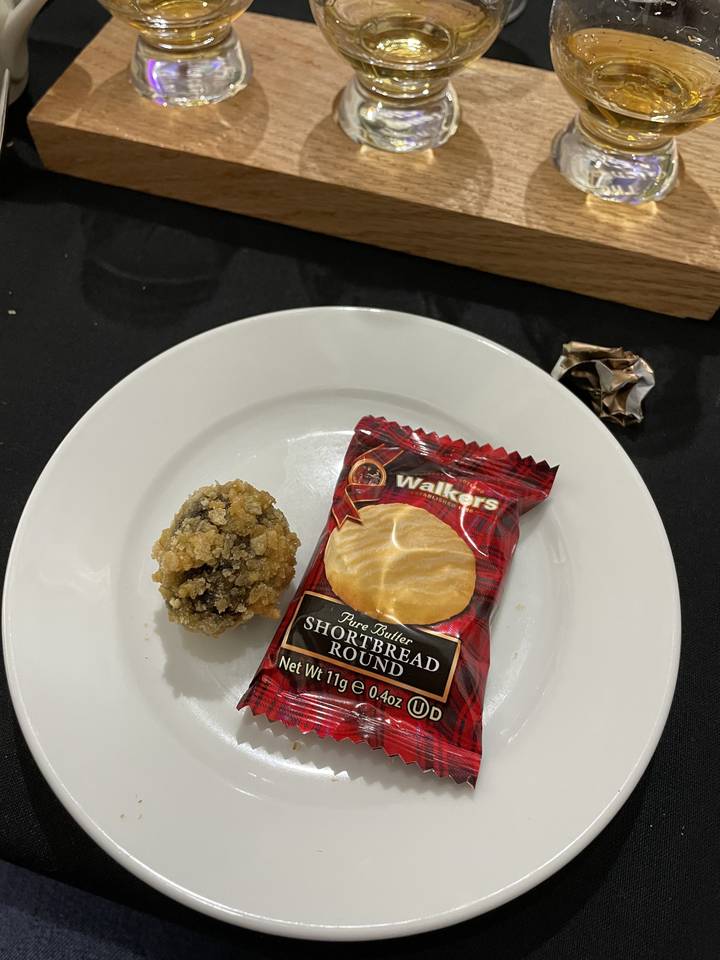 Un en-cas et des boissons sur une table, avec un emballage de sablés sur une assiette.