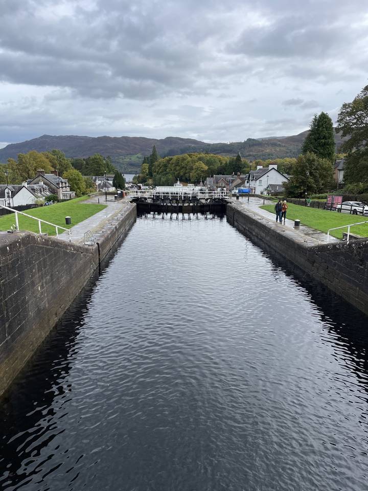 Un canal avec des écluses et des gens qui se promènent le long de celui-ci.