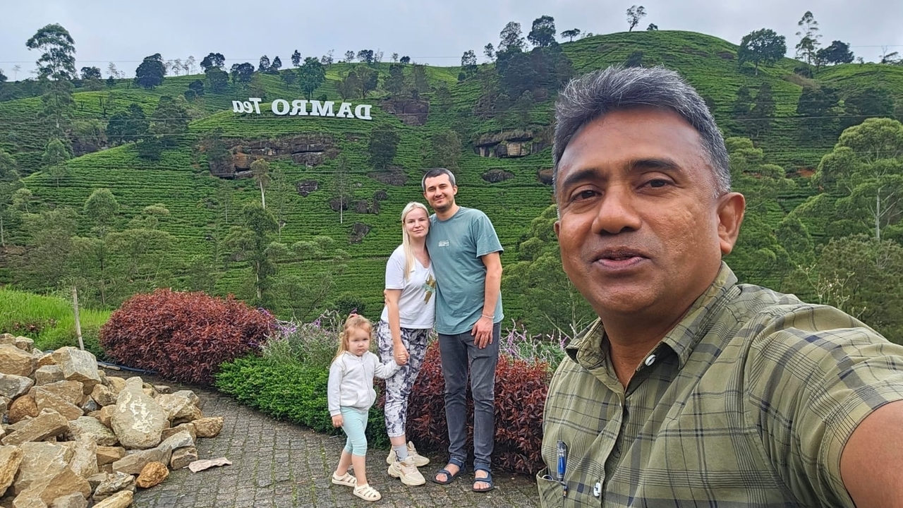 Famille posant devant un panneau et un paysage pittoresque.