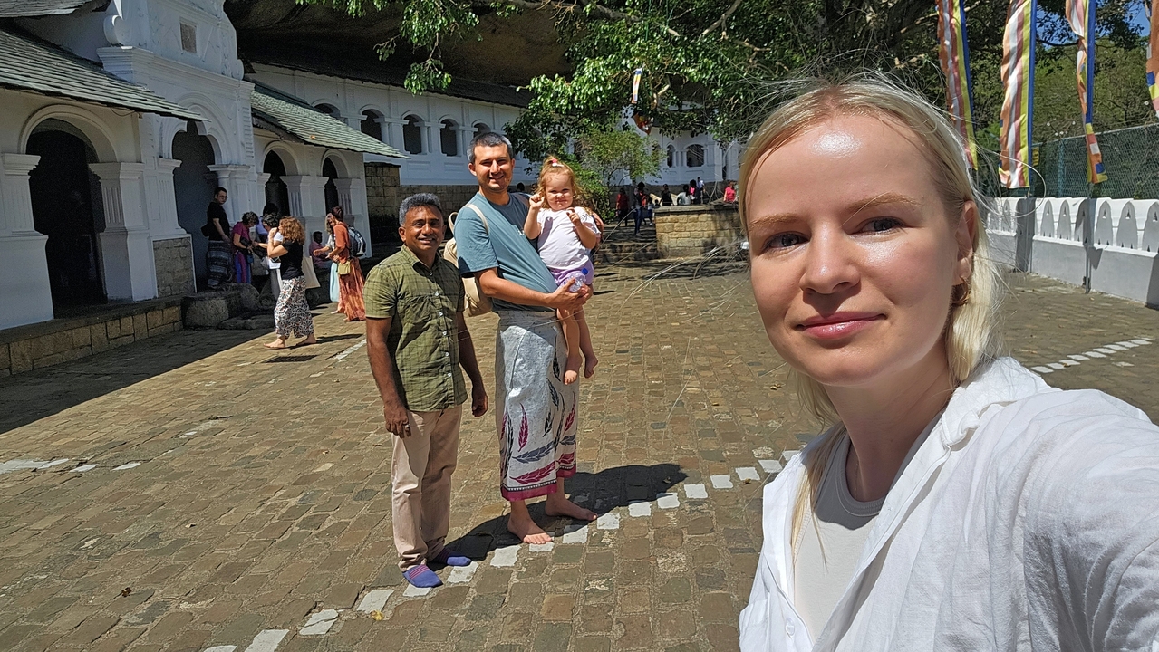 Des personnes debout devant un bâtiment historique.