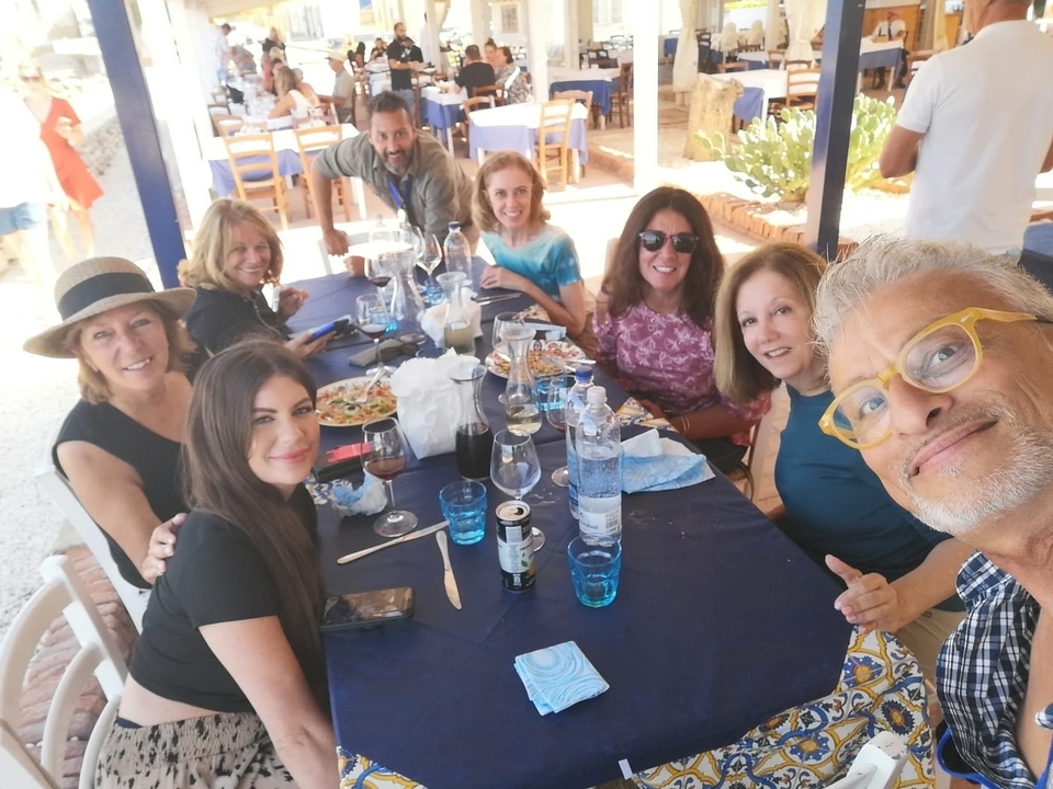 Groupe de personnes assises autour d'une table savourant un repas ensemble.