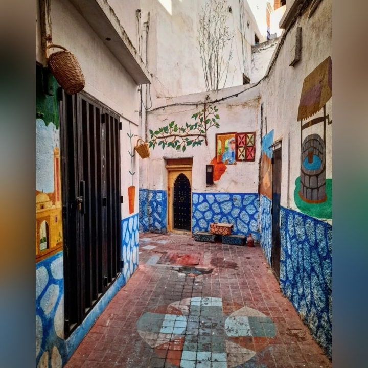 Ruelle étroite colorée avec murs peints et décoration.