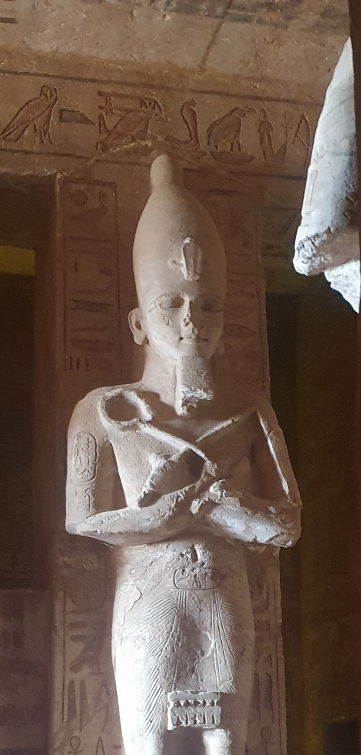 Statue ancienne dans un temple faiblement éclairé.