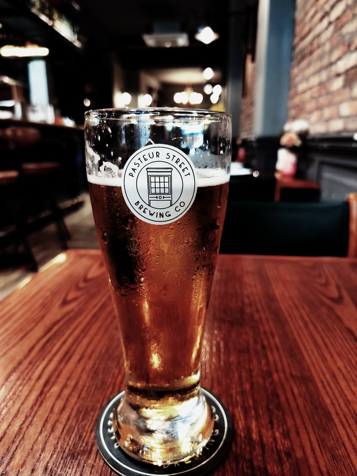 Gros plan d'une pinte de bière avec un logo visible.