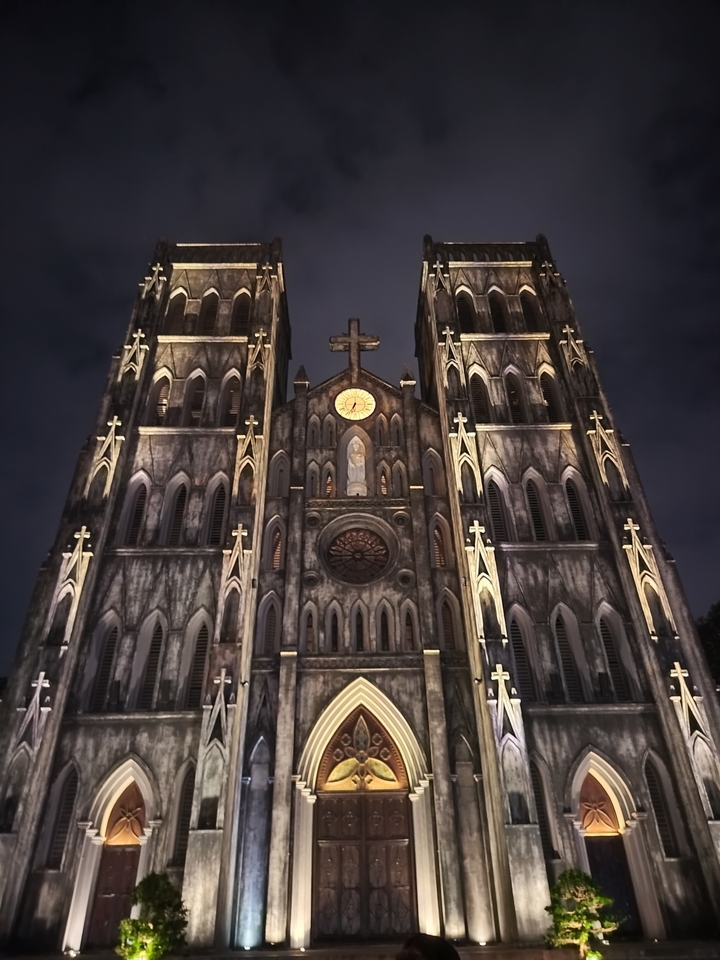 Façade de cathédrale illuminée la nuit.