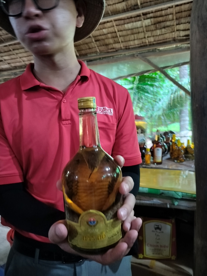 Personne tenant une bouteille avec du contenu conservé à l'intérieur.