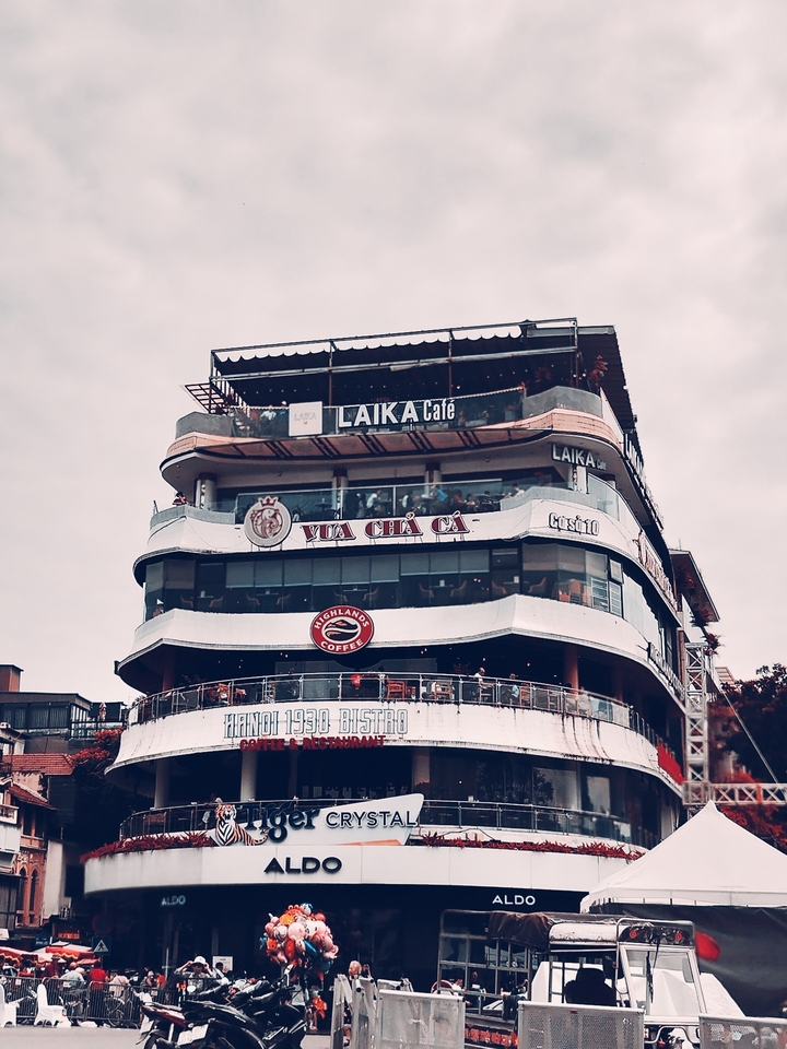 Bâtiment de café à plusieurs étages avec balcons ouverts.