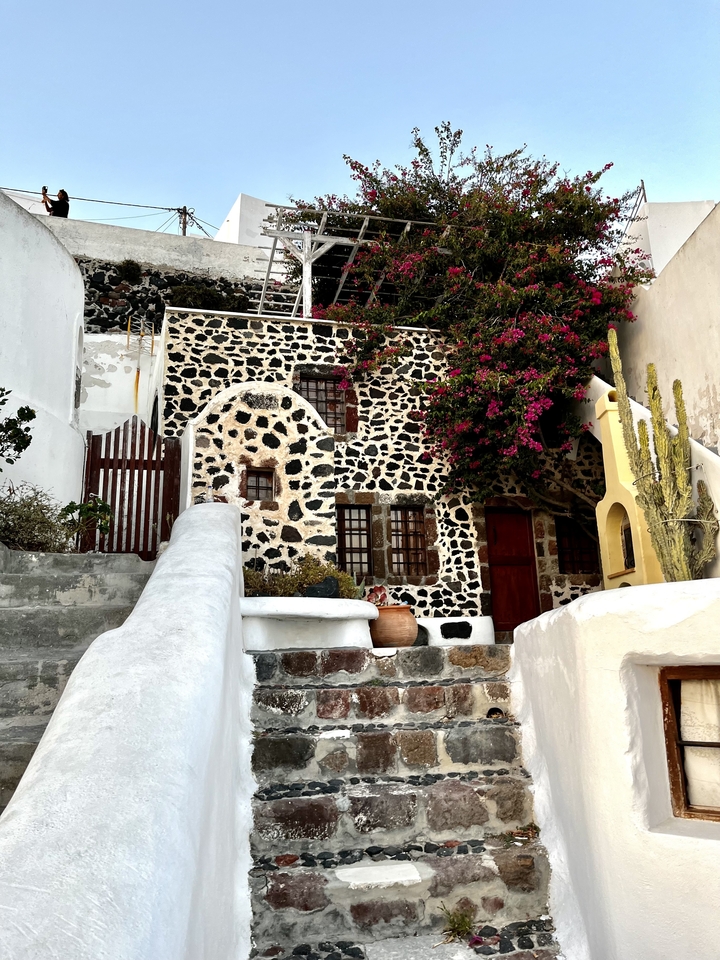 Maison traditionnelle avec façade en pierre et plantes.