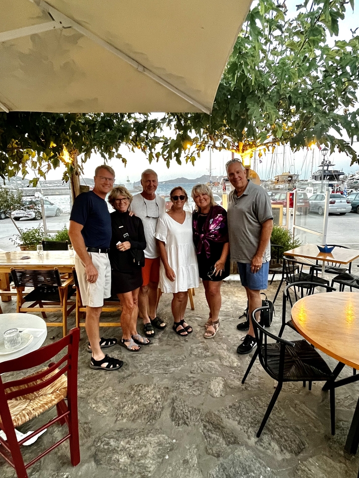 Groupe d'amis qui posent dans un restaurant en plein air.