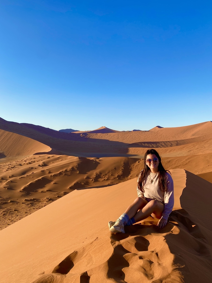 Personne debout sur une dune de sable dans le désert.