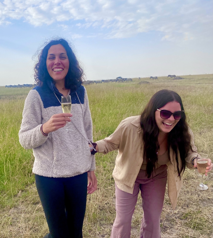 Deux femmes qui rient en tenant des verres de champagne.