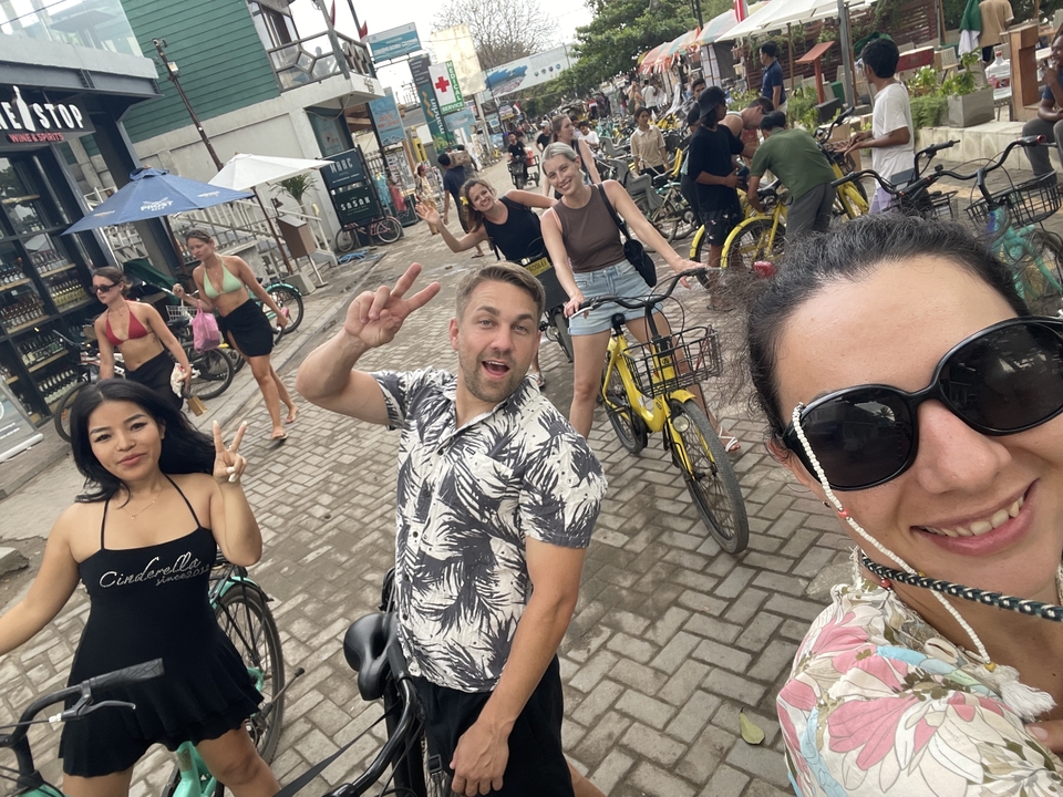 Des touristes à vélo profitant d'une scène de rue animée.