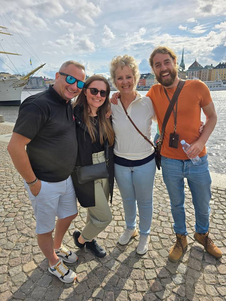 Groupe d'amis posant en extérieur dans une ville européenne.