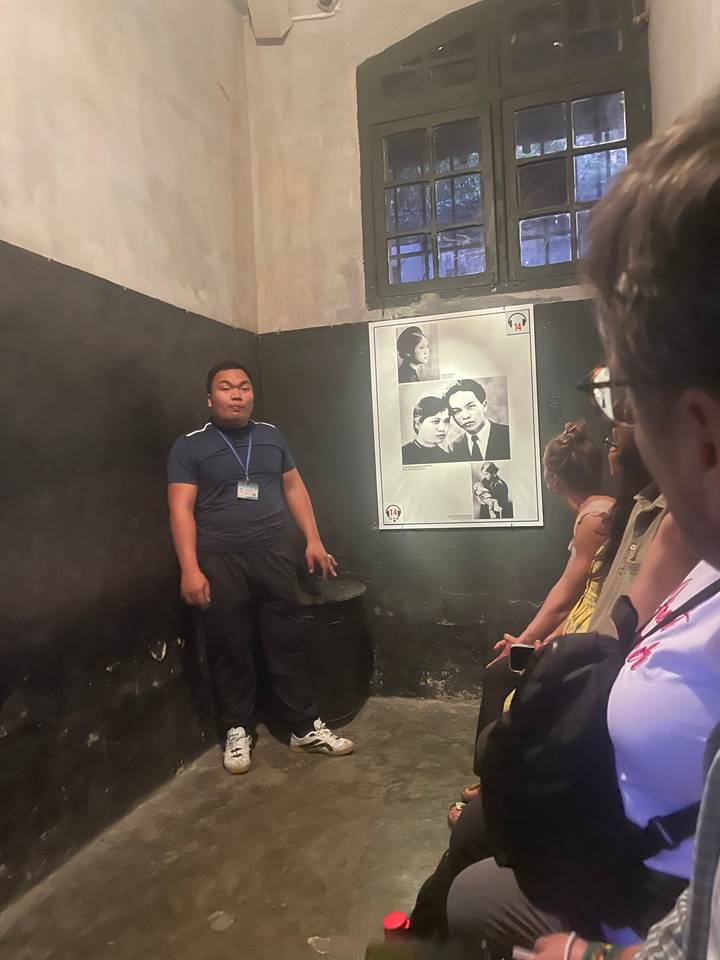 Homme assis dans une exposition intérieure.