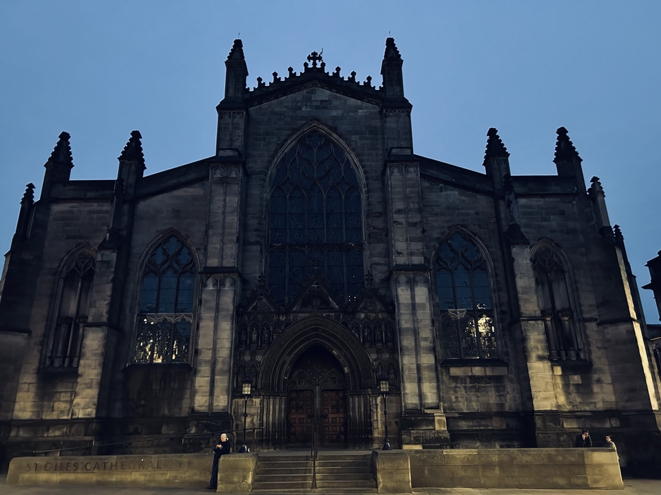 Une façade ornée de cathédrale en pierre illuminée la nuit.