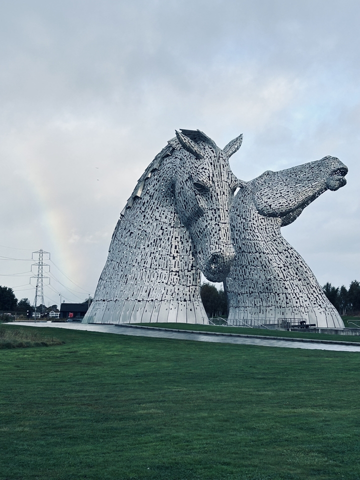 Deux grandes sculptures équines connues sous le nom de The Kelpies avec un arc-en-ciel.
