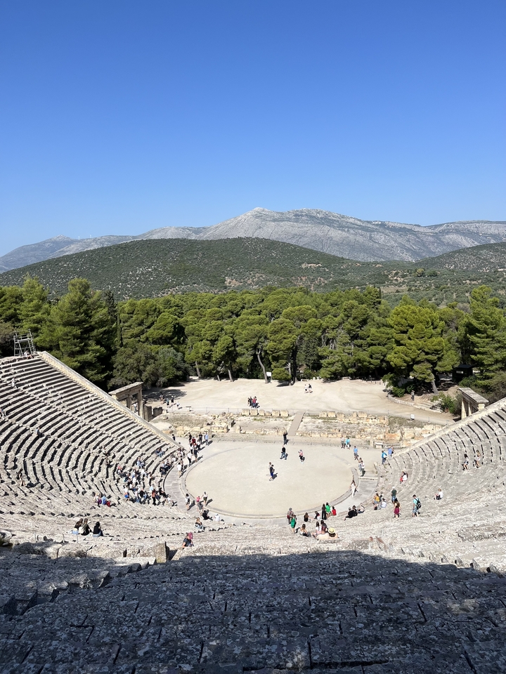 Vue aérienne d'un théâtre antique entouré d'arbres.
