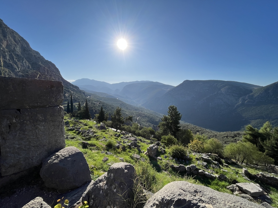 Montagnes et vallée avec le soleil dans un ciel bleu clair.