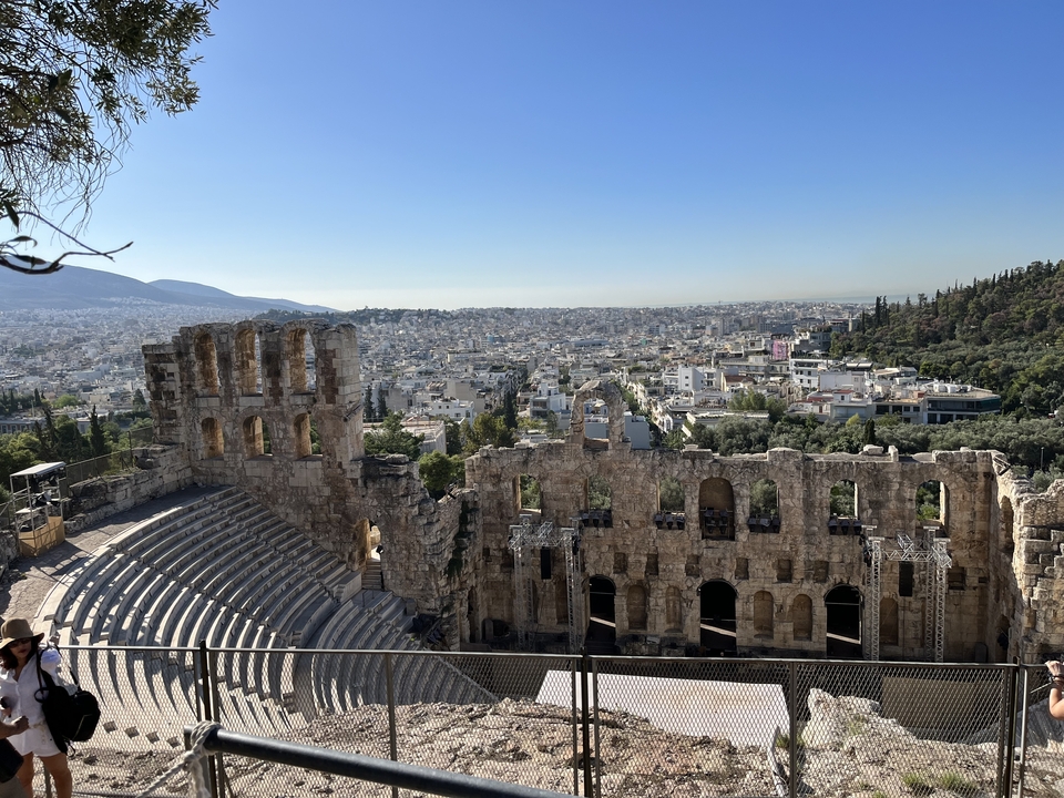Ruines de théâtre surplombant un paysage urbain.